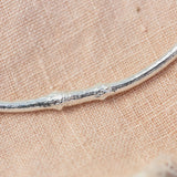 silver smooth twig necklace on pink cloth