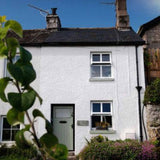 front of white cottage with blue skies