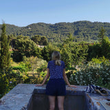 back of woman looking out at forest from balcony