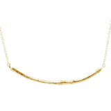 gold smooth twig necklace on white background