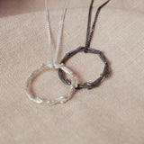 silver wreath pendant next to oxidised wreath pendant