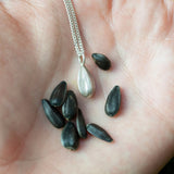 Silver Sunflower seed pandant necklace in hand, hand made in uk