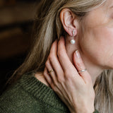 Person wearing a pearl and siver twig earring