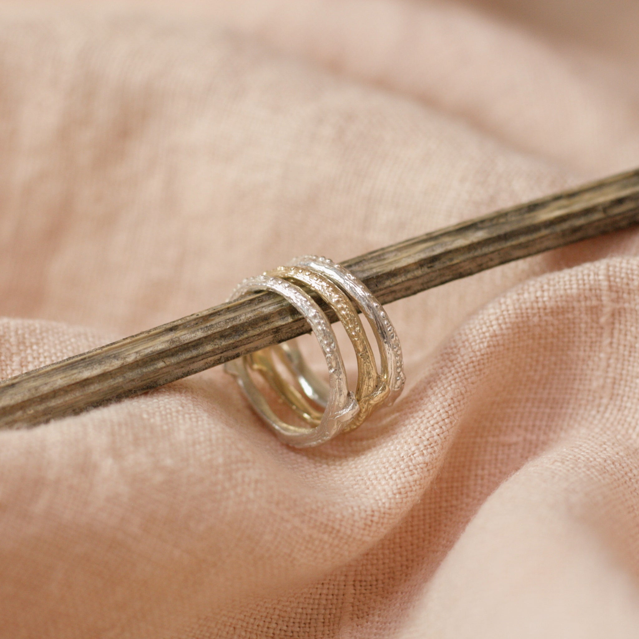 Three Stem Stacking Rings on stem above pink cloth