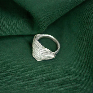 silver artichoke leaf ring on green cloth