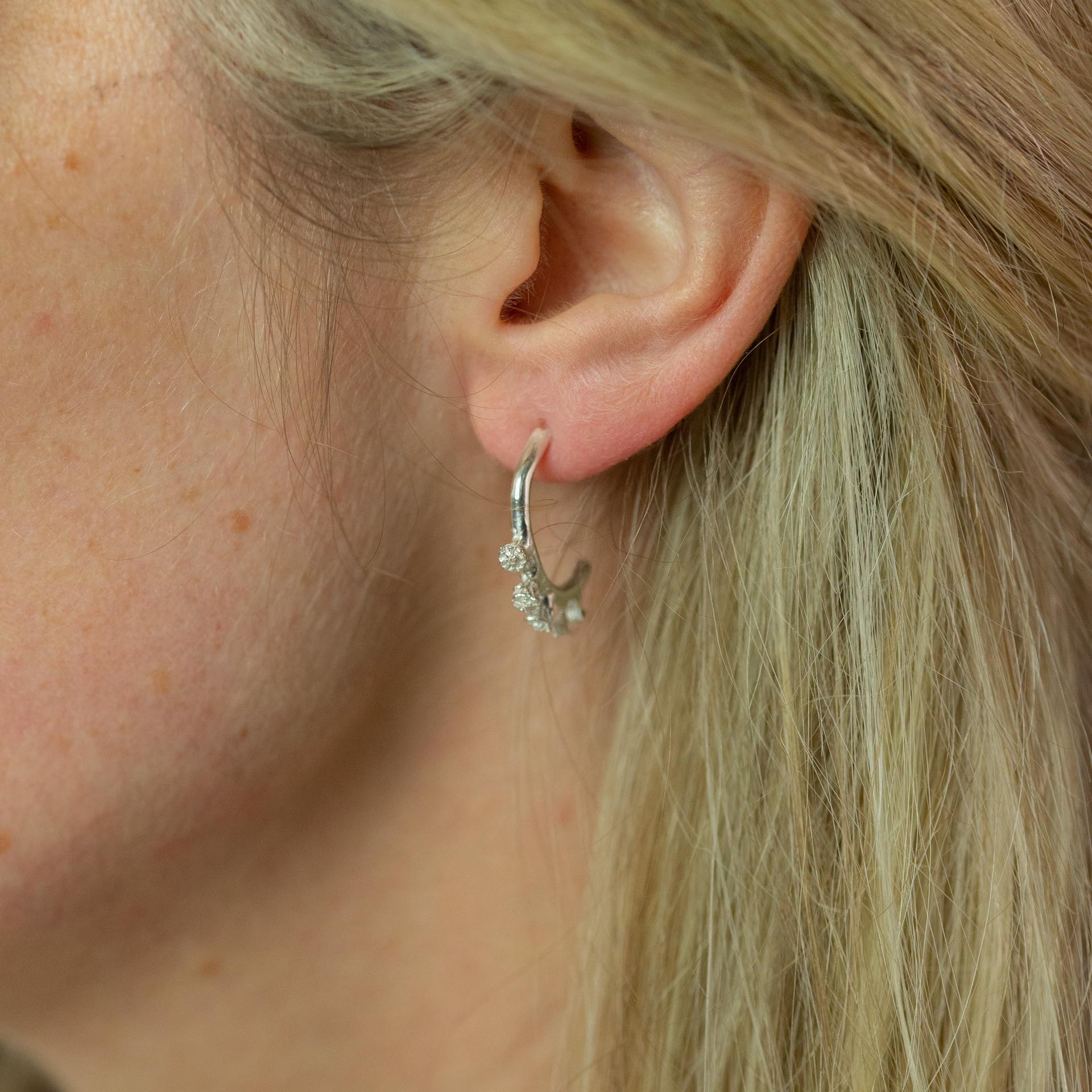 Silver Ivy bud half hoop earrings modelled on ear