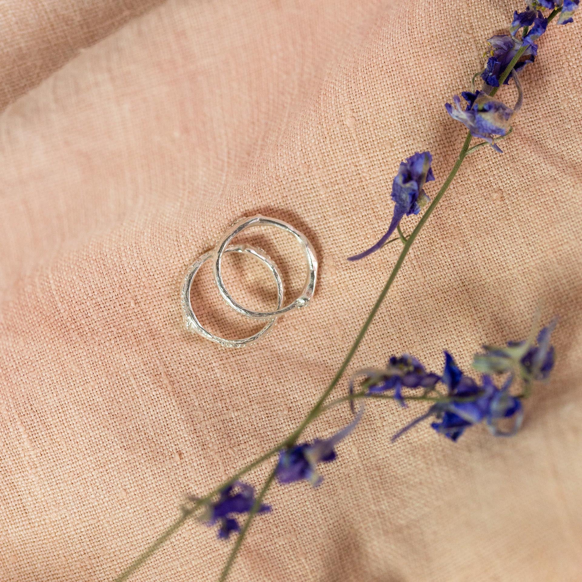 silver and gold stem stacking rings on pink cloth