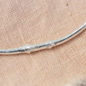 silver smooth twig necklace on pink cloth