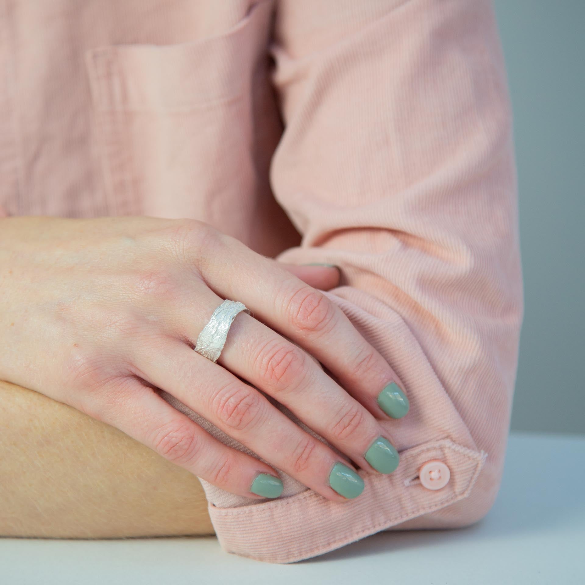 Snow Drop Leaf Wrap Ring modelled on hand resting on arm with pink shirt