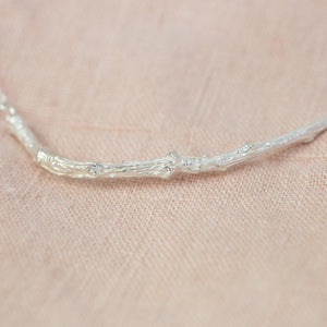 Silver Textured Twig Necklace on pink cloth
