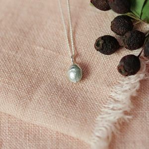 yew berry silver necklace on pink cloth