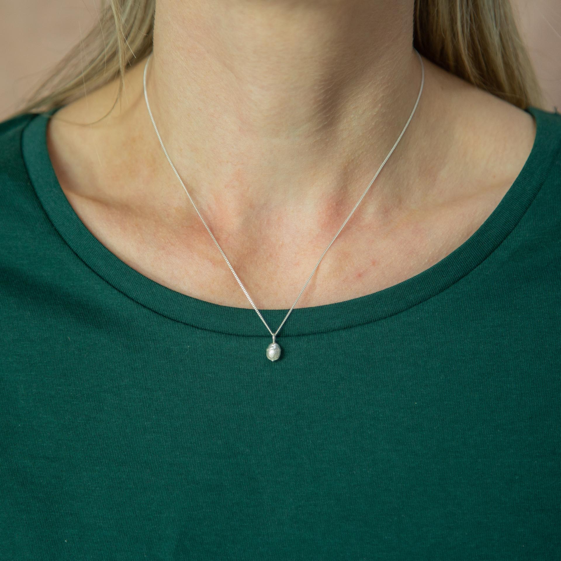 yew berry silver necklace modelled around neck on green tshirt