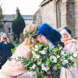an embrace at a wedding with a large bouquet of flowers