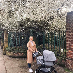 woman under tree with pushchair 