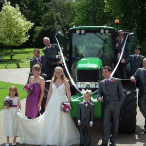 wedding party in front of green tractor