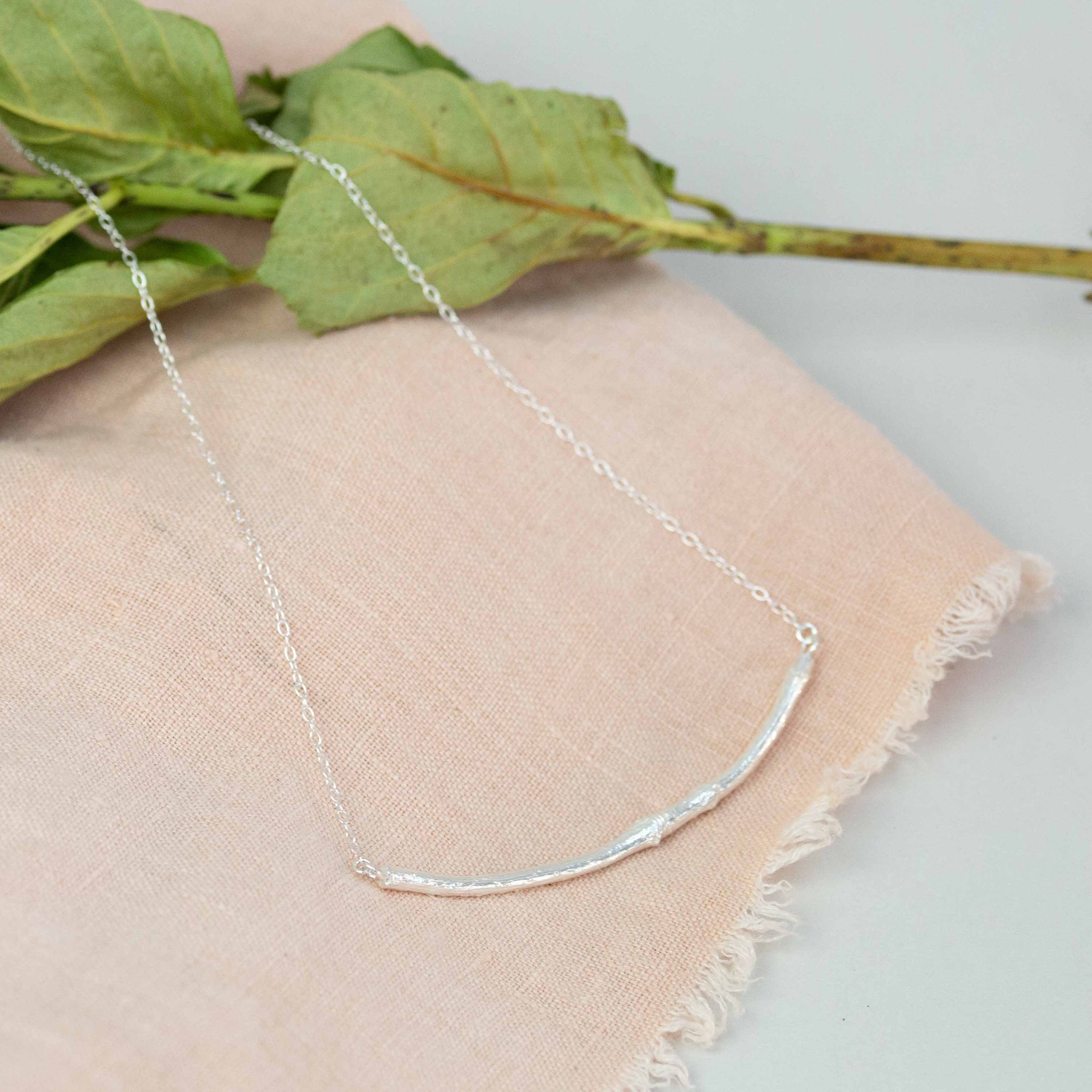 silver bar necklace on pink cloth