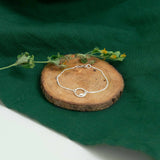 silver eternity bracelet on wood above green cloth